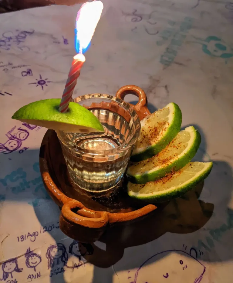 Shot of tequila with limes with a burning candle